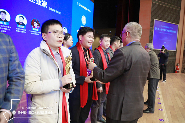 中國木材與木制品流通協(xié)會副會長兼秘書長李佳峰（左六）為“2019紅木家具杰出青年企業(yè)家”獲獎?wù)邆ッ鬈幖t木董事長張石乃頒獎