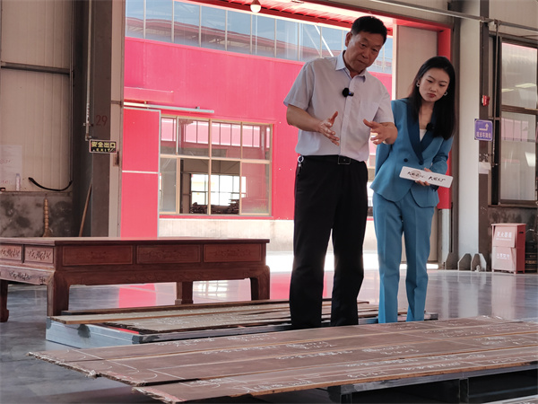巧奪天工紅木董事長張愛冬(左)給主持人講解“一木一器”制作過程 巧奪天工紅木董事長張愛冬(左)給主持人講解“一木一器”制作過程