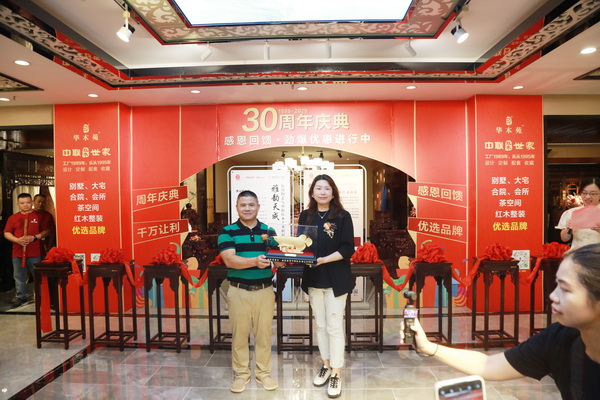 順聯(lián)家居匯南區(qū)總經(jīng)理竇珊（右）向中聯(lián)紅木世家（華木苑）董事總經(jīng)理周志華（左）贈禮